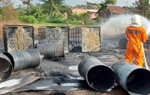 Petugas memadamkan api di lokasi penimbunan BBM Solar daerah Simpang Pasir Samarinda. (Istimewa)